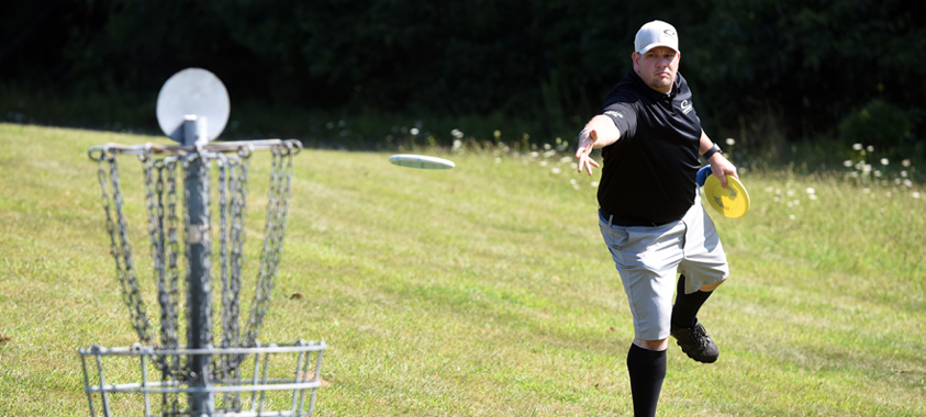 A golfer watches his frisbee fly toward the goal at the Addison Oaks Disc Golf Course