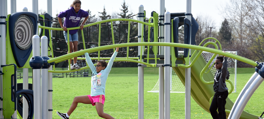 Children playing on the monkey bars at Catalpa Oaks