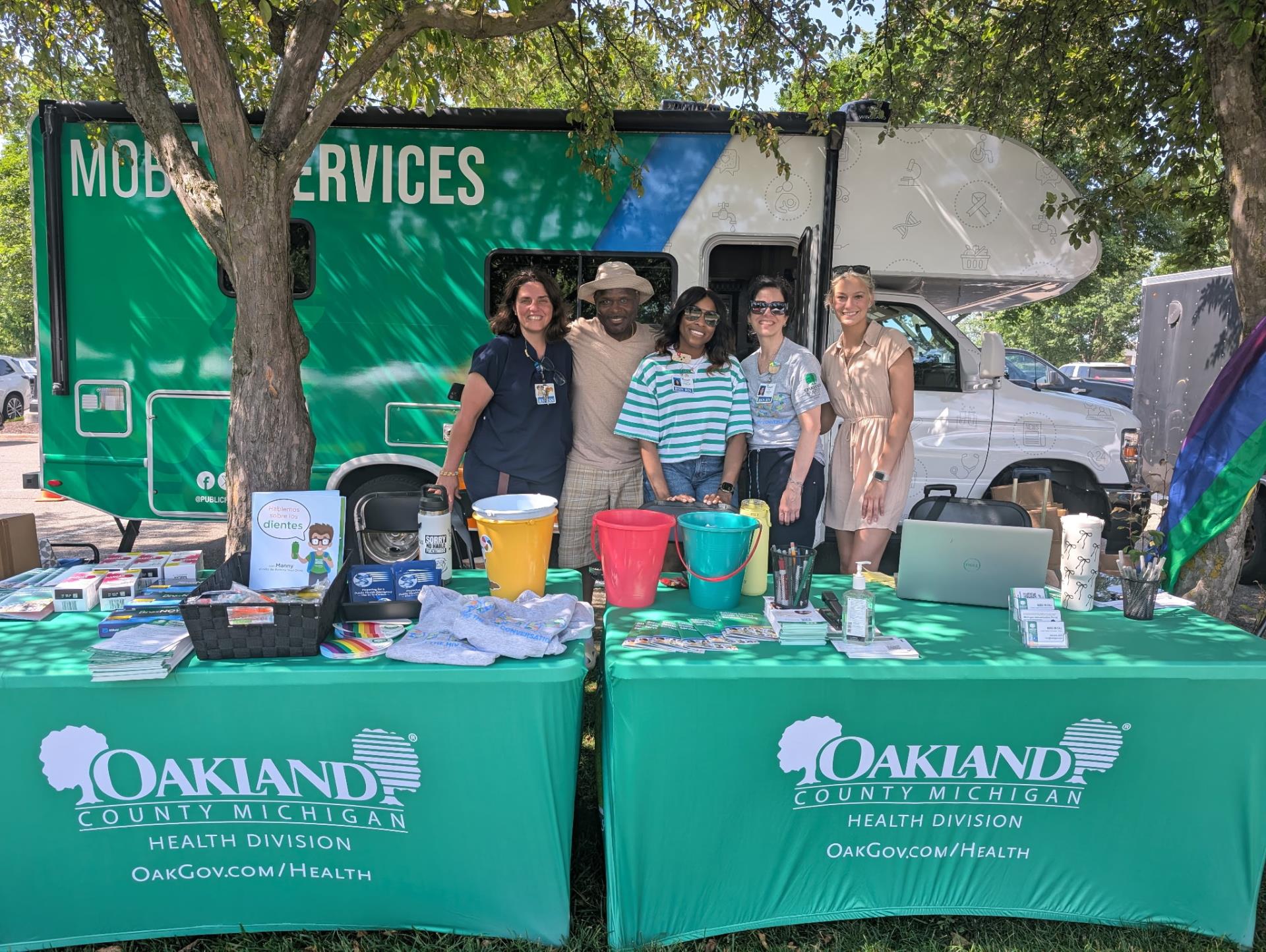 OC HHS staff at outreach event in front of mobile unit with display
