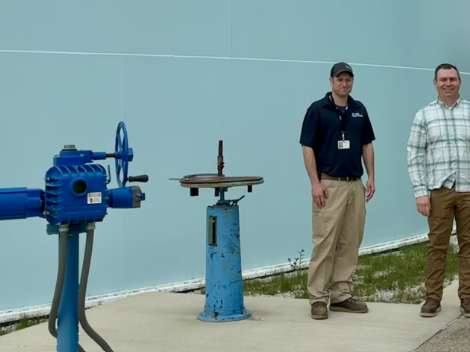 Two WRC employees in front of a water tank