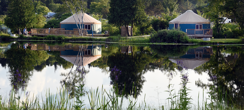 View of two Yurts across the lake at Groveland Oaks