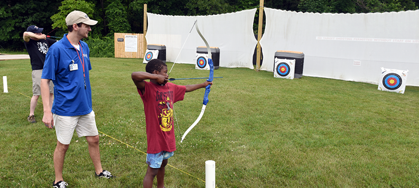 A child takes aim at a target on the archery range at Independence Oaks