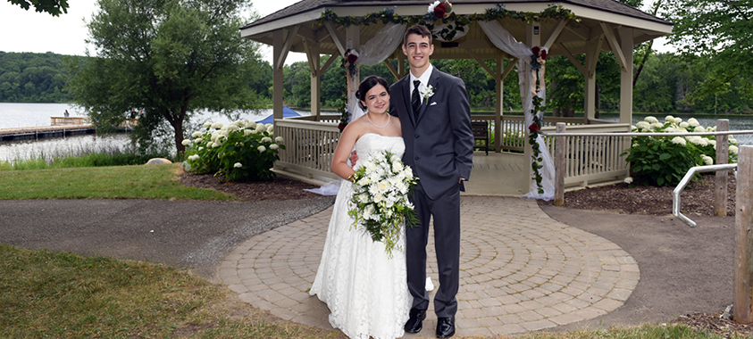 A newlywed couple poses after their marriage ceremony near the gazebo at Independence Oaks