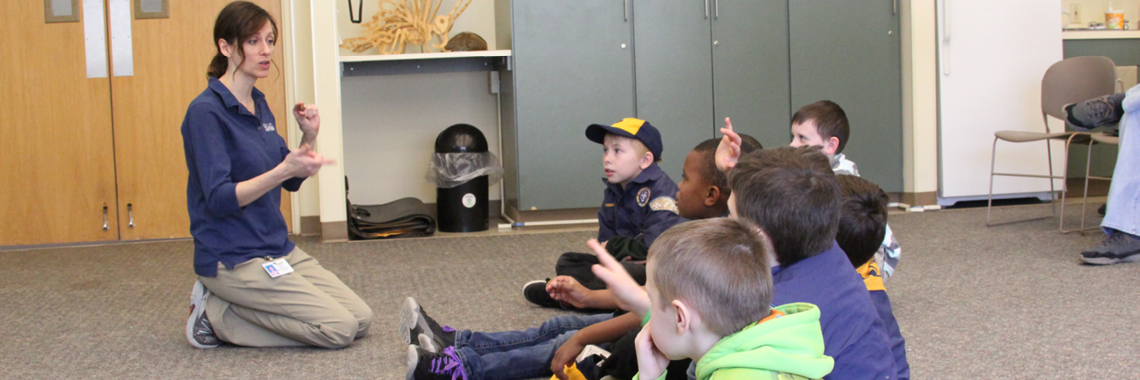 Cub scouts listening to an instructor in side the facilities at Wint Nature Center