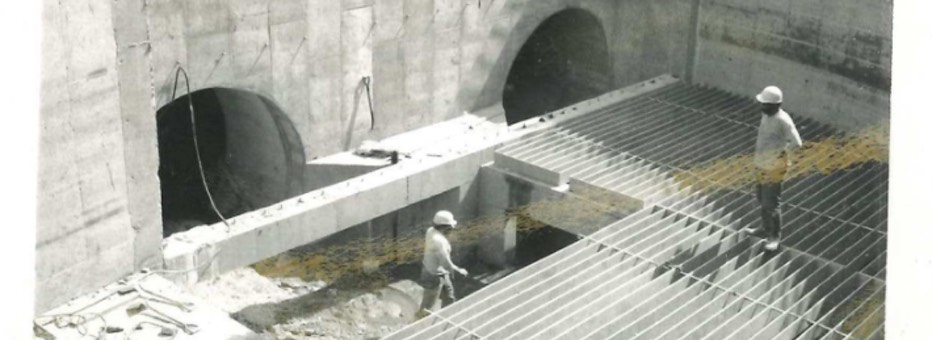 Two workers inside empty water basin during construction