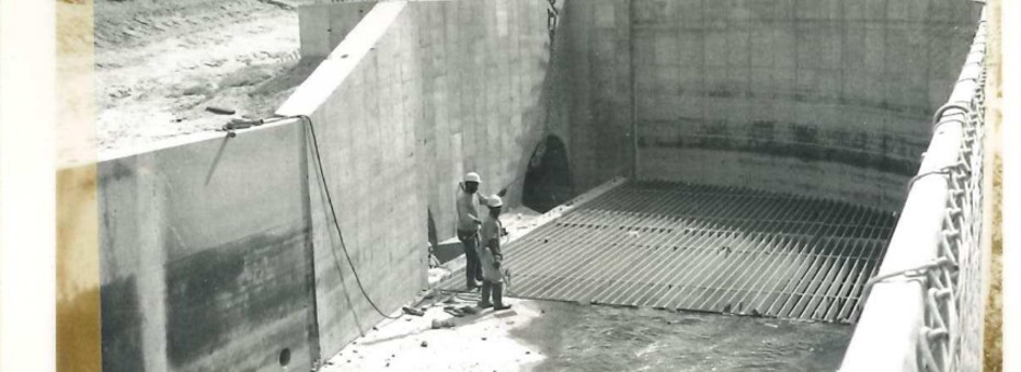 Historic photo of two workers inside of empty water basin.